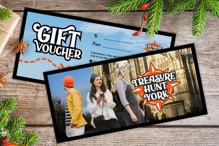 A gift voucher for Treasure Hunt York on a table covered with Christmas decorations